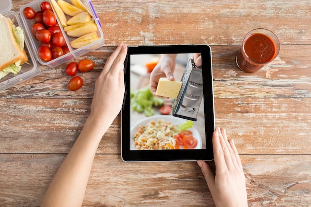 Vrouw kijkt naar een kookvideo op een tablet.