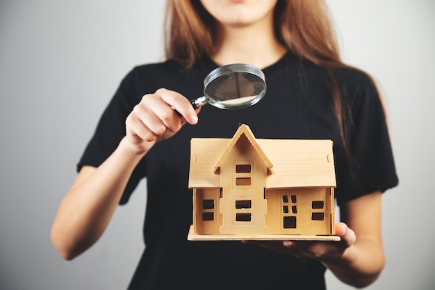 Foto vrouw kijkt naar het huis met een vergrootglas