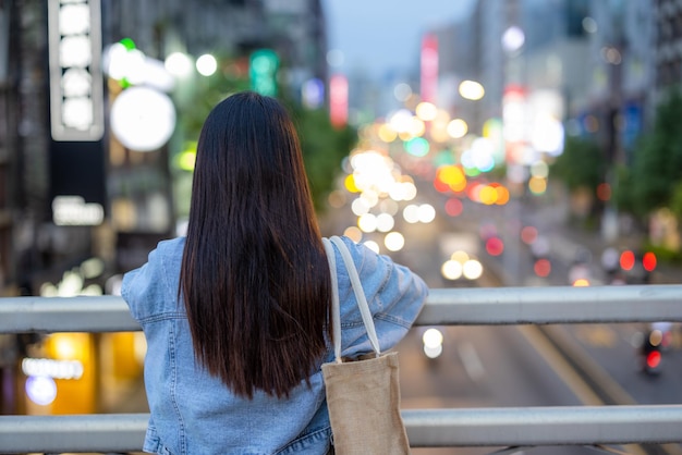 Vrouw kijkt naar het uitzicht op de stad in de avond