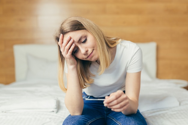 Vrouw klaagt over zwangerschapstest zittend op de bank