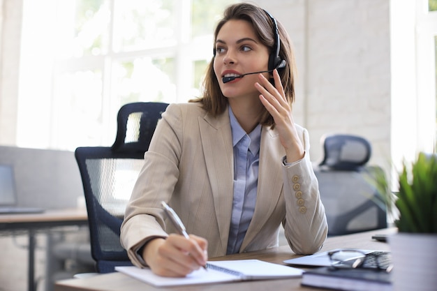 Vrouw klantenondersteuning operator met headset en glimlachen.