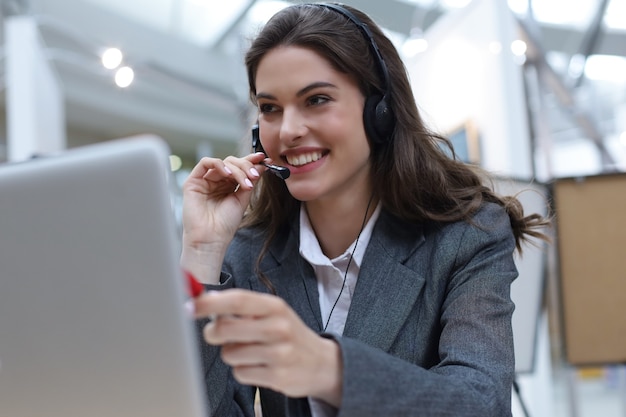 Vrouw klantenondersteuning operator met headset en glimlachen.