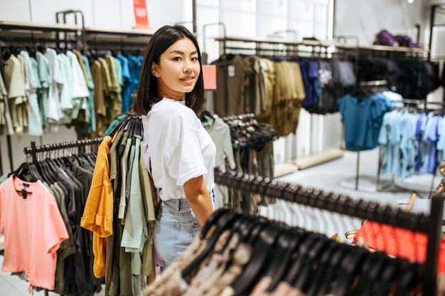 Vrouw kleren in kledingwinkel kiezen