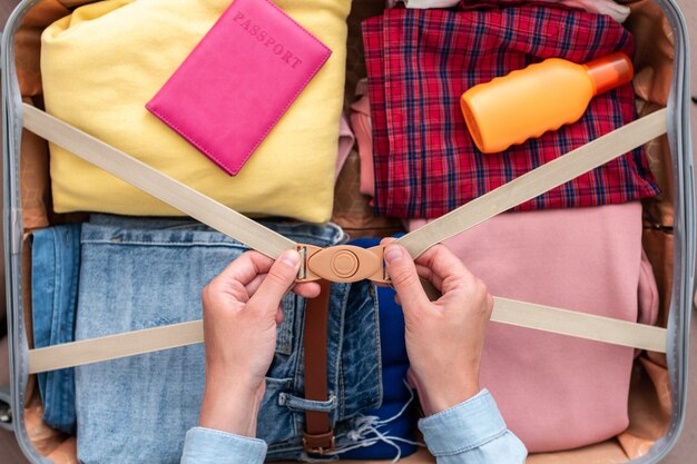 Vrouw kleren verpakken in een koffer voor een nieuwe reis en reizen. bagage voor reisvakanties en vakantie. bovenaanzicht