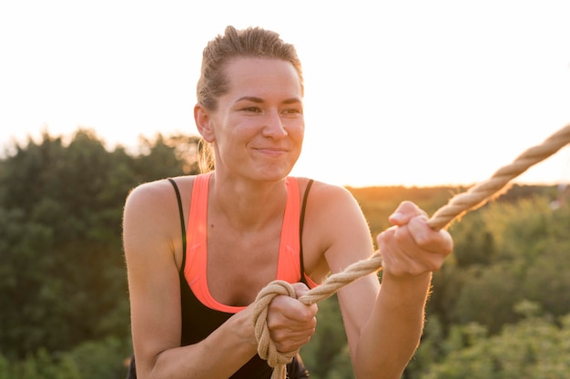 Vrouw klimmen met de hulp van een vriend en een touw