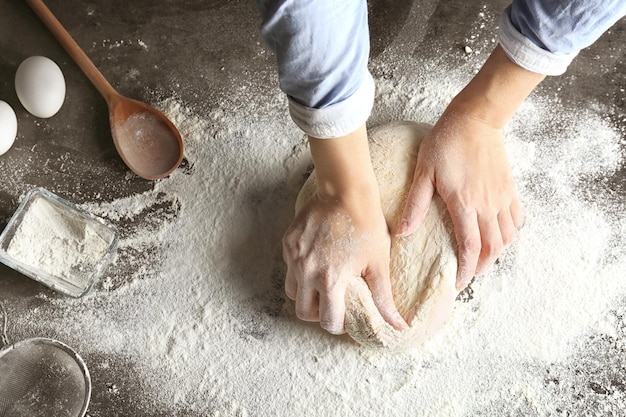 Vrouw kneden van deeg op de keukentafel