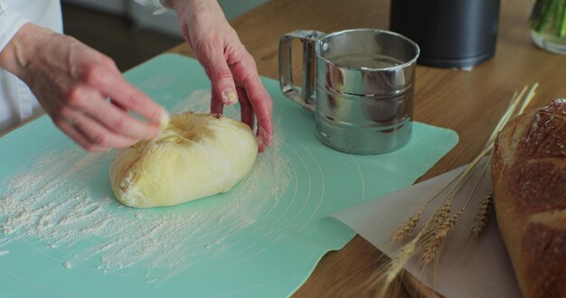 Vrouw kneedt het deeg in de keuken koken thuis genieten van hobby handgemaakt brood maken