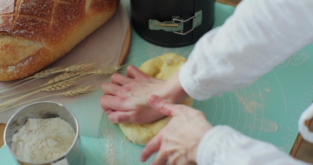 Foto vrouw kneedt het deeg in de keuken koken thuis genieten van hobby handgemaakt brood maken