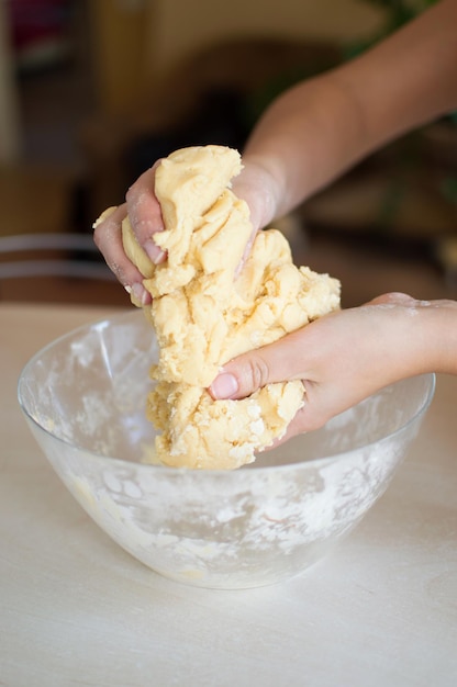 Vrouw kneedt het deeg voor het koken van huismaaltijden