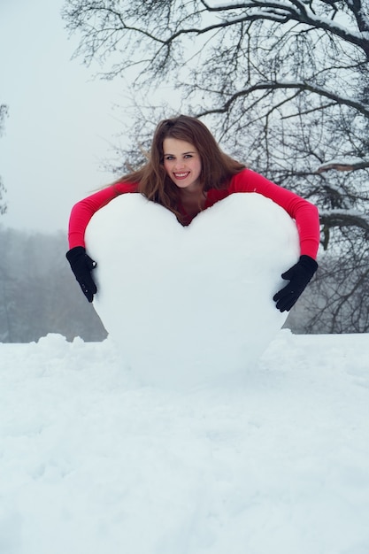 Vrouw knuffelen het hart uit de sneeuw