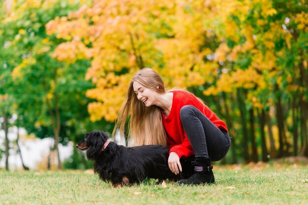 Vrouw knuffelen hond in het zomerpark