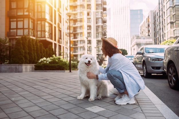 Vrouw knuffelt een grote hond bij zonsondergang