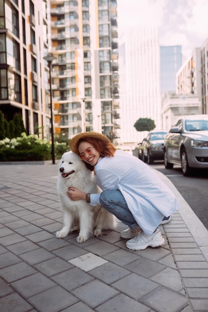 Vrouw knuffelt een grote hond bij zonsondergang