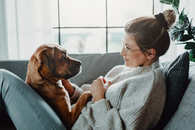 Vrouw knuffelt thuis met haar hond