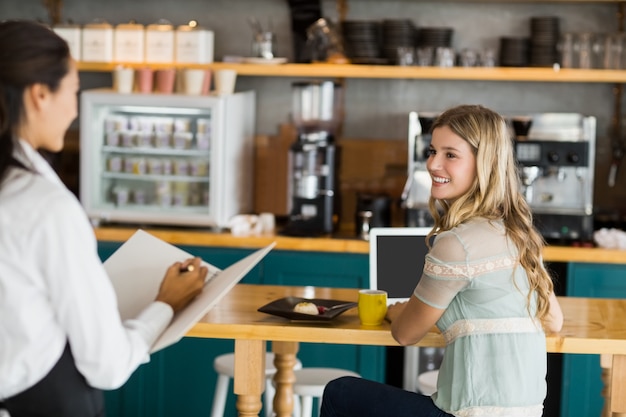 Vrouw koffie bestellen bij serveerster