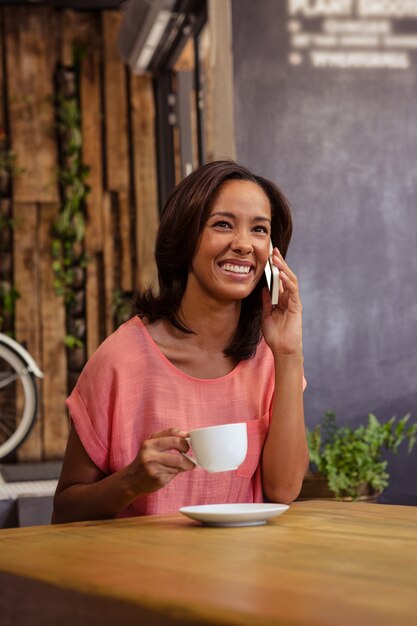 Vrouw koffie drinken en het gebruik van smartphone