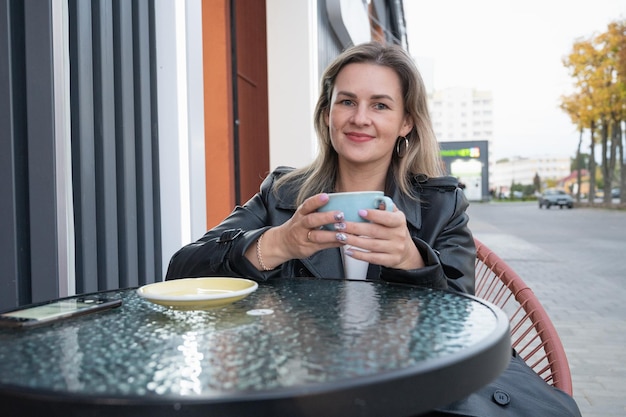 Vrouw koffie drinken in een café buitenshuis