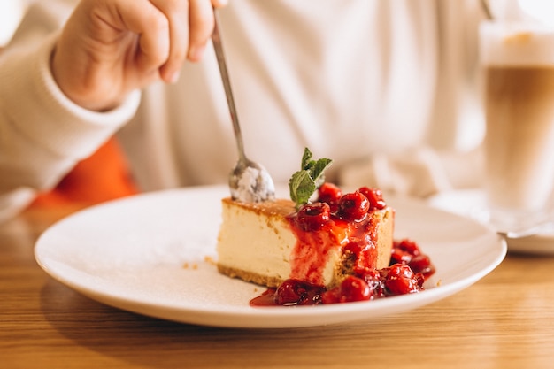 Vrouw koffie drinken met dessert in een café