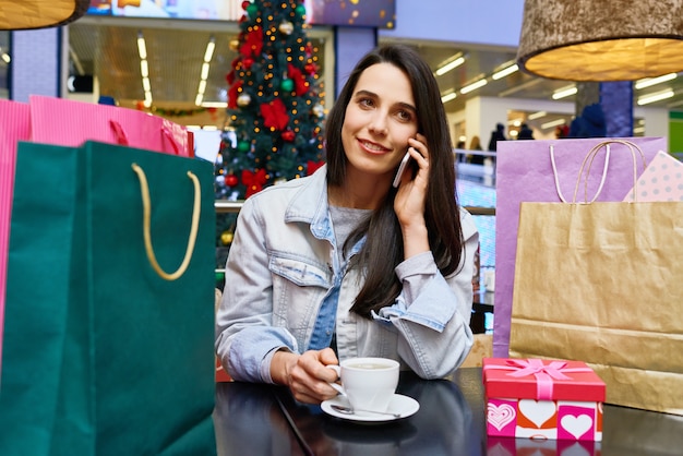 Vrouw koffie drinken na het winkelen