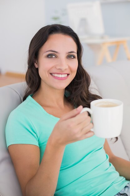 Vrouw koffie drinken op de bank