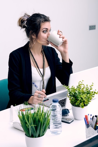 Vrouw koffie drinken op de werkplek