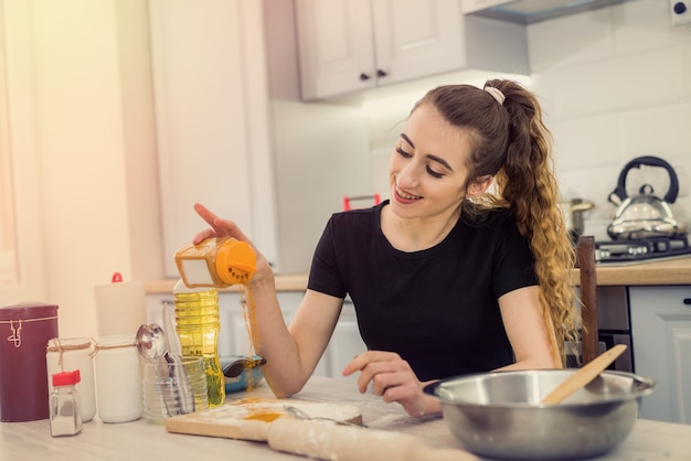 Vrouw koken bakkerij eten, ingrediënten mengen: meel, eieren, olie en andere.