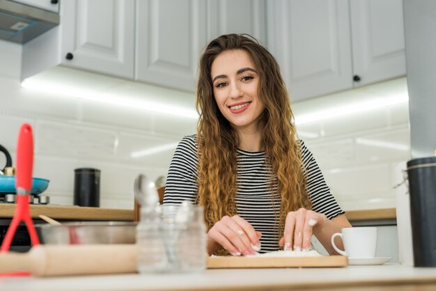 Vrouw koken bakkerij eten, ingrediënten mengen: meel, eieren, olie en andere.