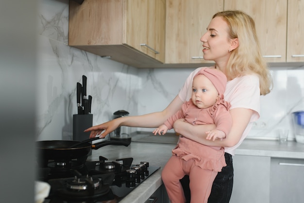 Vrouw koken met haar dochtertje in handen