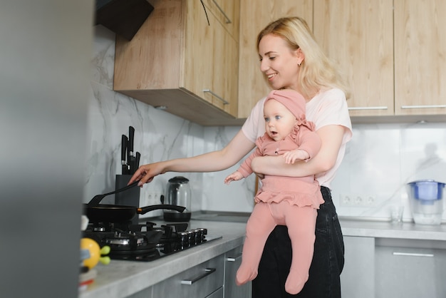 Vrouw koken met haar dochtertje in handen