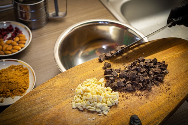 Foto vrouw koken smakelijke gesmolten chocolade op tafel in de keuken delicious dessert gemaakt van zelfgemaakte chocolade