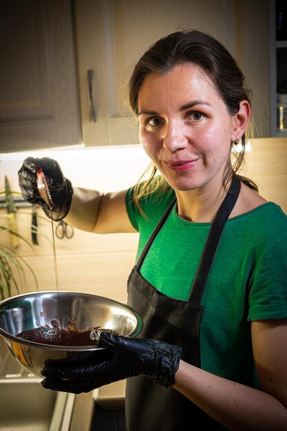 Foto vrouw koken smakelijke gesmolten chocolade op tafel in de keuken delicious dessert gemaakt van zelfgemaakte chocolade