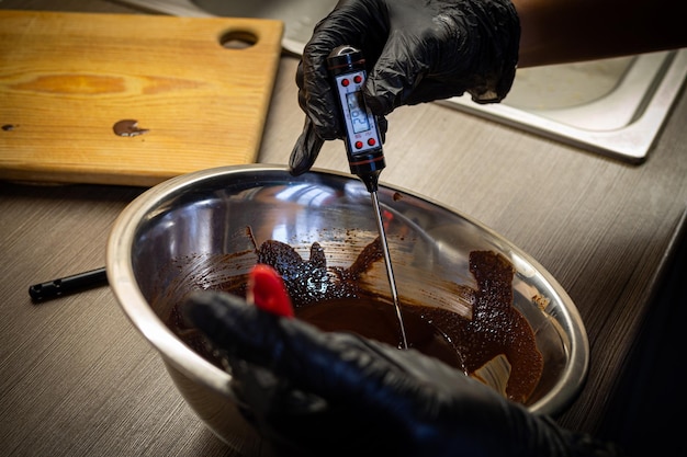 Foto vrouw koken smakelijke gesmolten chocolade op tafel in de keuken delicious dessert gemaakt van zelfgemaakte chocolade