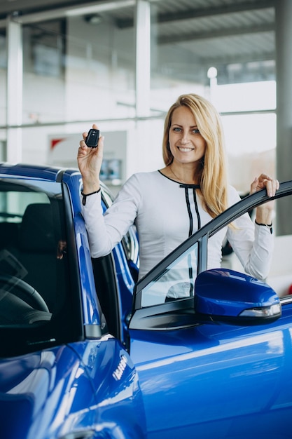 Vrouw koopt een nieuwe auto in een autosalon