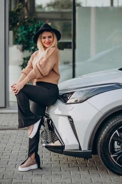 Vrouw koopt nieuwe auto in autoshowroom