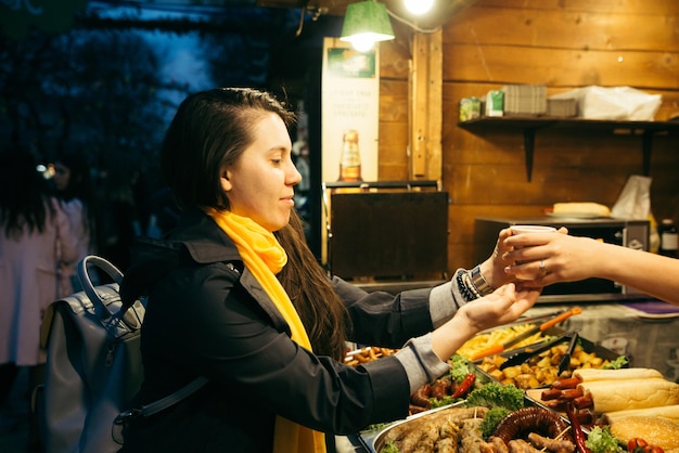 Vrouw koopt straatvoedsel op straatvoedselfestival
