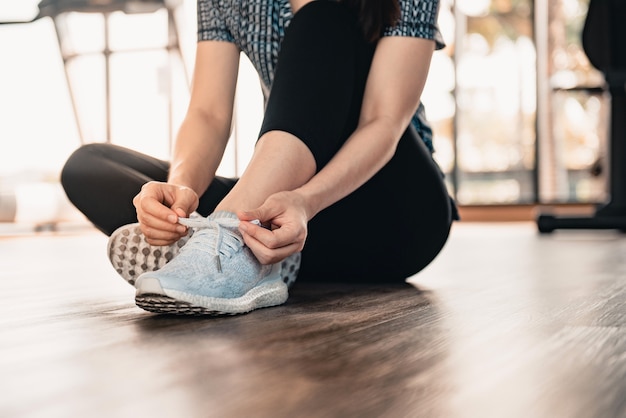 Vrouw koppelverkoop loopschoenen op verdieping in sportschool fitness