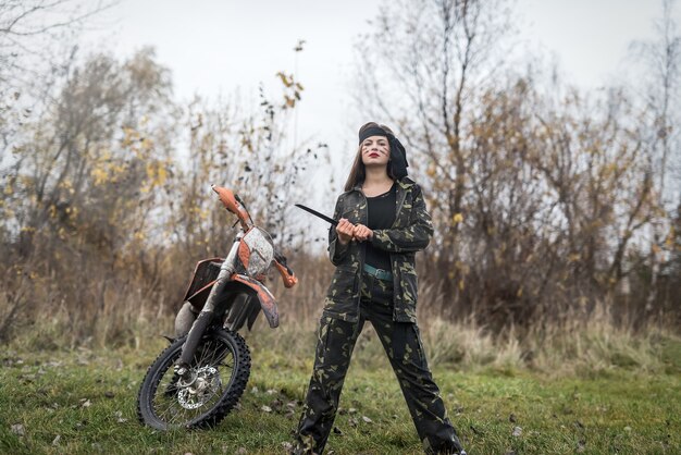 Vrouw krijger in camouflage vorm poseren buitenshuis