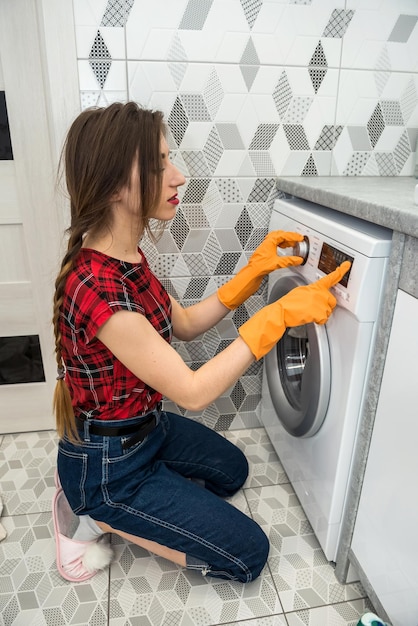 Vrouw laadt de waskleren in de wasmachine.