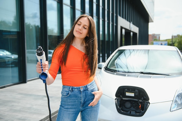 Vrouw laadt elektrische huurauto op