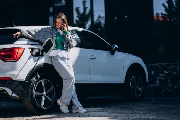 Vrouw laadt haar elektrische auto op met oplaadpistool