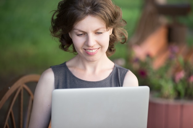 Vrouw lachend tijdens het typen op laptop