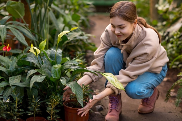 Vrouw lachend tuinieren planten pot in kas