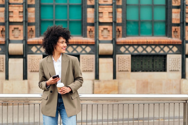 Vrouw lacht blij met een mobiele telefoon in de hand