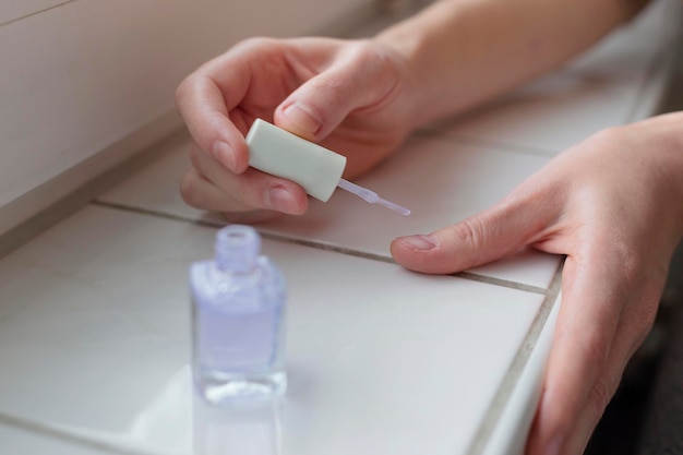Vrouw lakt haar nagels met transparante veganistische nagellak Eco zelfzorg