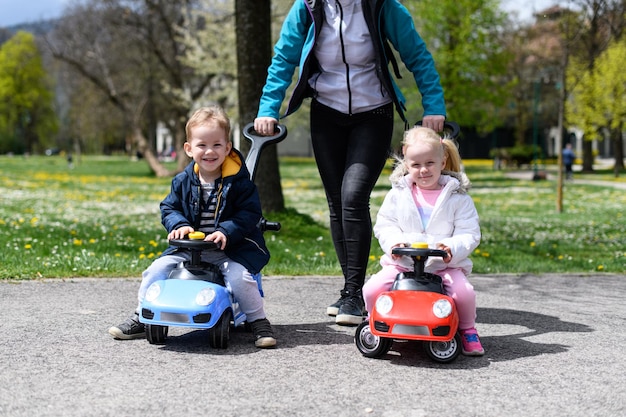 Vrouw leert haar kinderen speelgoedautootjes te besturen