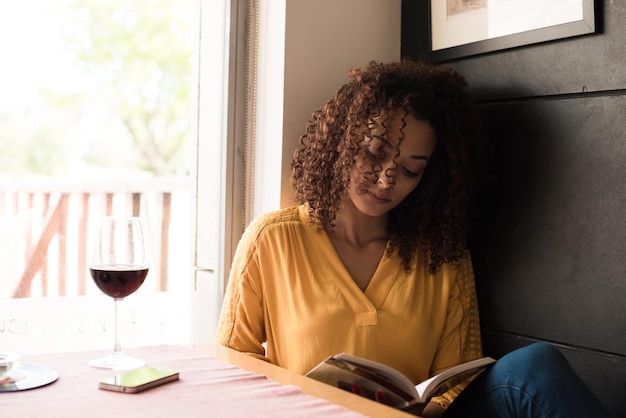 Vrouw leesboek bij coffeeshop