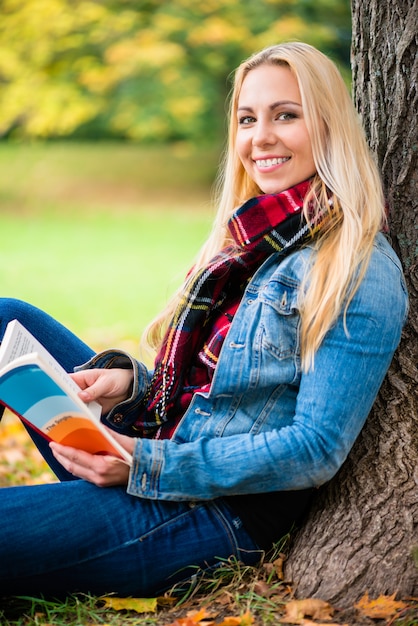 Vrouw leesboek in herfst park