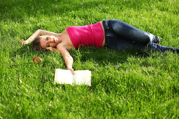 Vrouw leesboek in het park op het gras