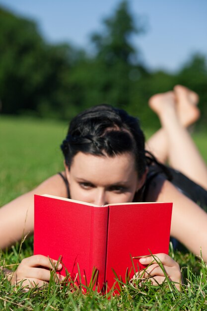 Foto vrouw leesboek op weide