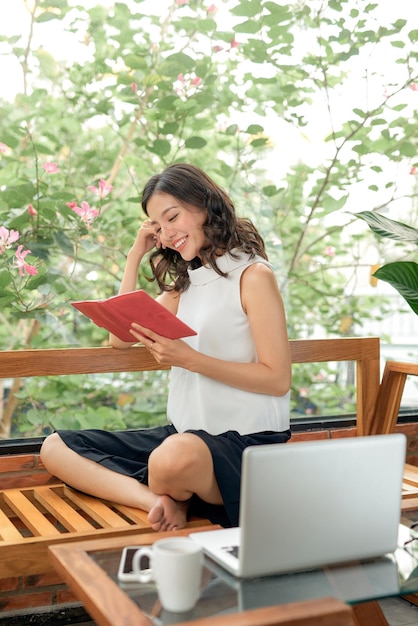 Vrouw leest dagboek op de bank thuis